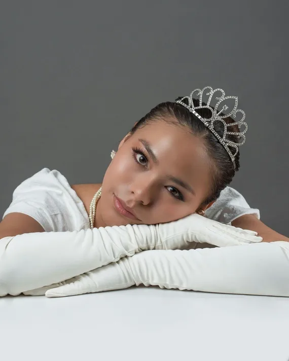 Debutante de tiara e luvas brancas