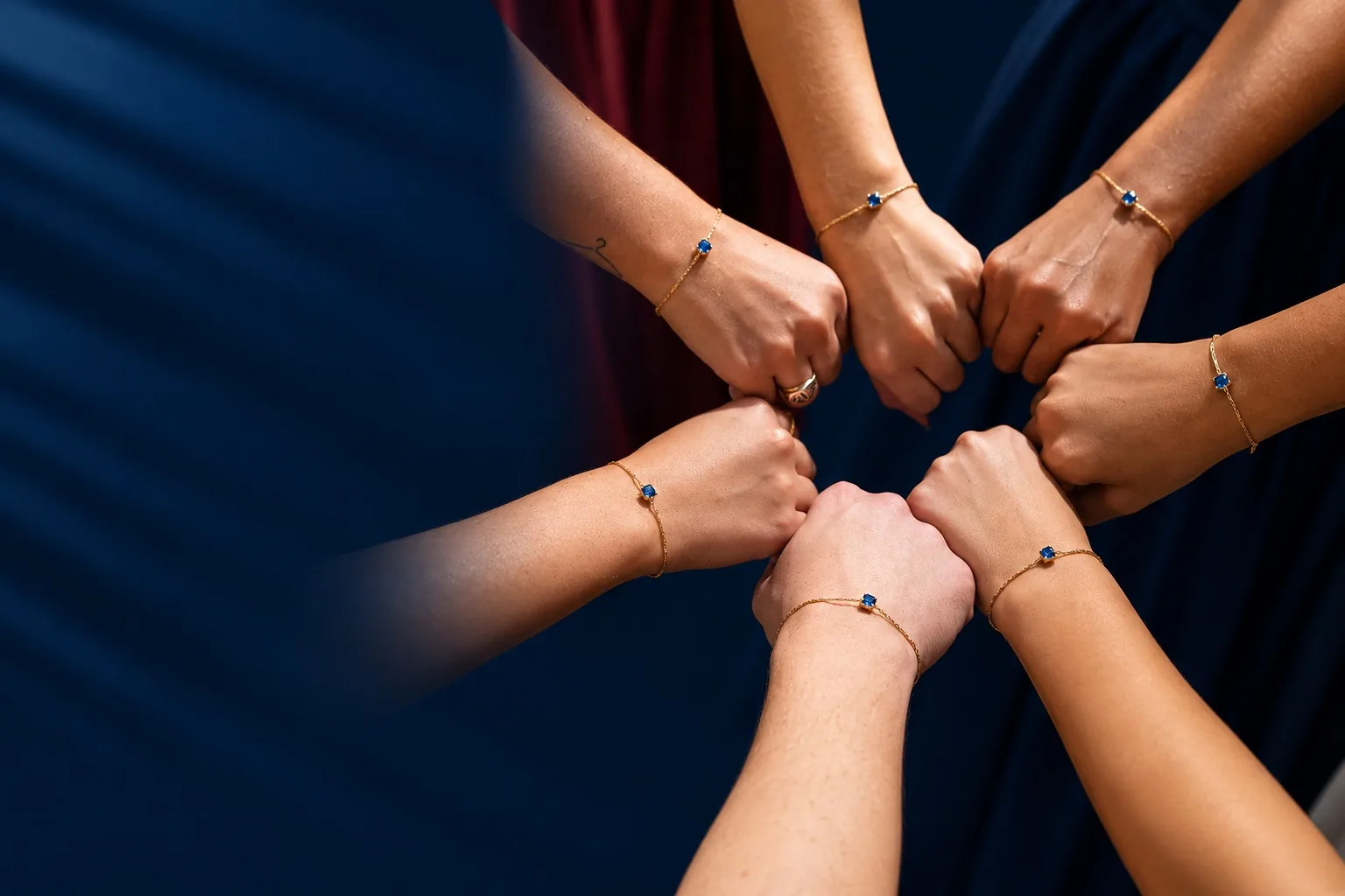 Debutante e amigas reunindo as mãos com pulseiras Riê